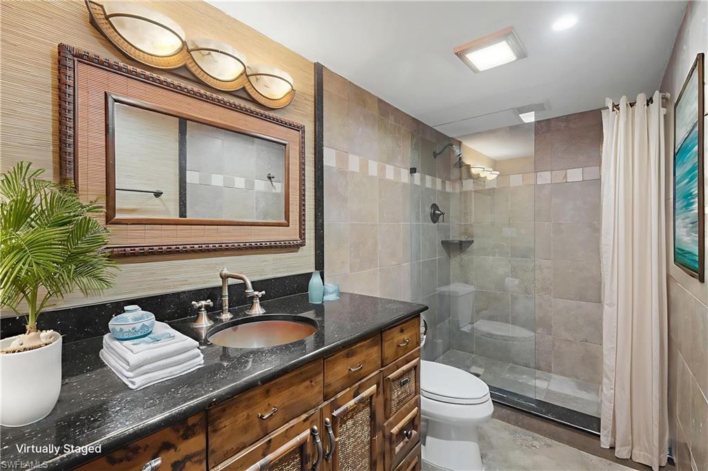 4160 Crayton Road, Unit A8 Naples, FL 34103 - Photo 7 of 26 a bathroom with a granite countertop sink toilet and shower