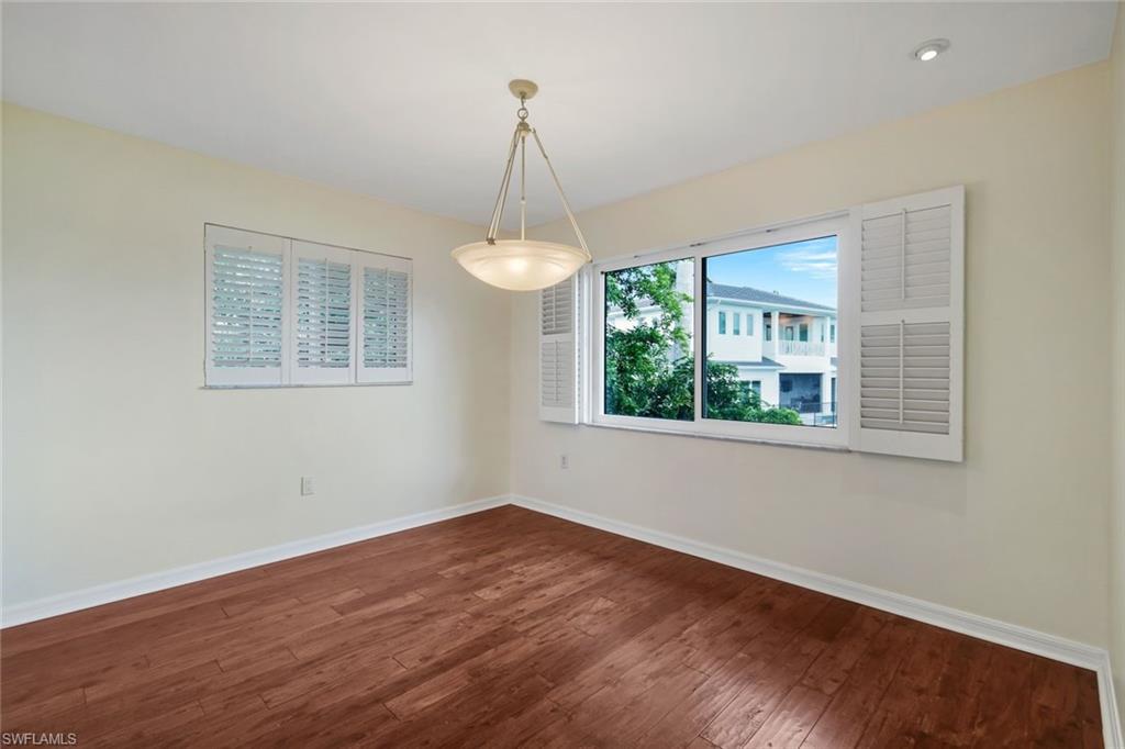 4160 Crayton Road, Unit A8 Naples, FL 34103 - Photo 10 of 26 a view of an empty room with wooden floor and a window