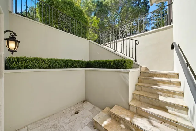 an aerial view of a house with swimming pool and large trees