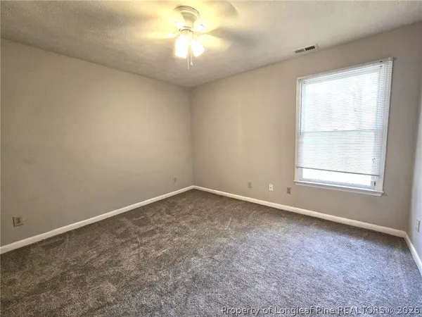 an empty room with a chandelier fan