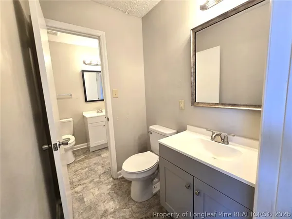 a bathroom with a sink a toilet and a mirror