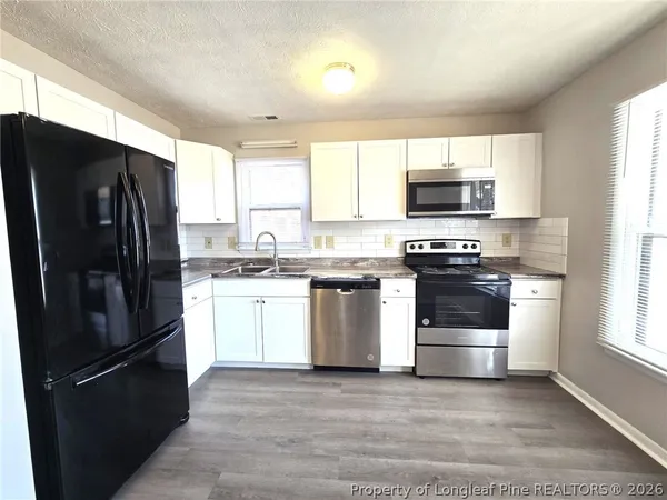 a kitchen with a refrigerator stove and microwave