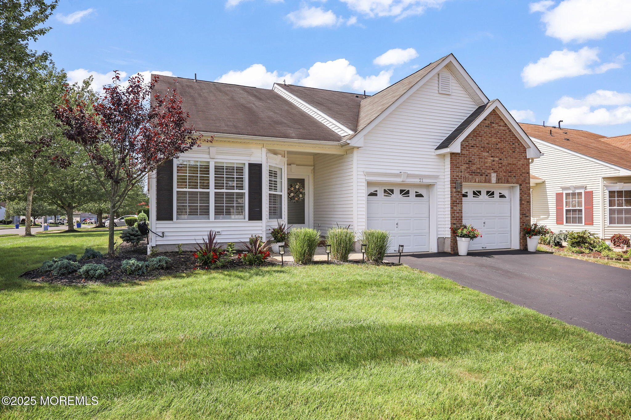 a front view of a house with a garden and trees