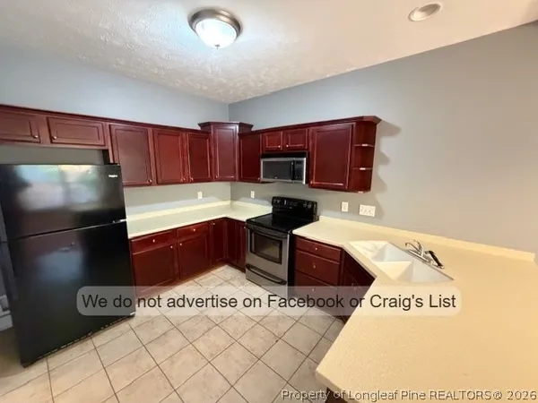 a kitchen with stainless steel appliances granite countertop a refrigerator sink and stove
