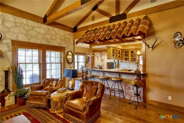 a living room with furniture fireplace and a large window