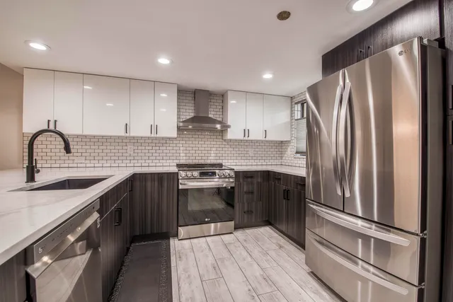 a kitchen with stainless steel appliances granite countertop a sink stove and refrigerator