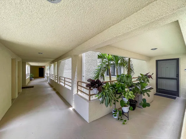 a hallway with potted plants and a large window
