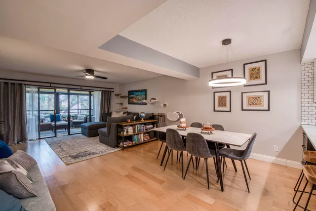 a living room with furniture a large window and kitchen view