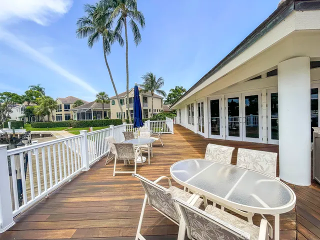 a view of a patio with couches chairs potted plants and wooden floor