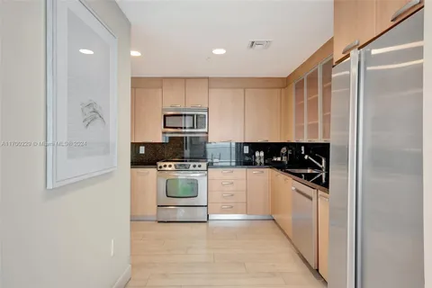 a kitchen with white cabinets and appliances