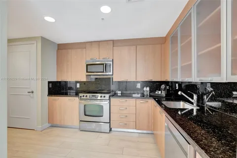 a kitchen with granite countertop a stove sink and cabinets