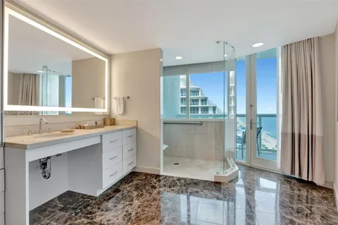 a bathroom with a granite countertop sink a toilet and shower