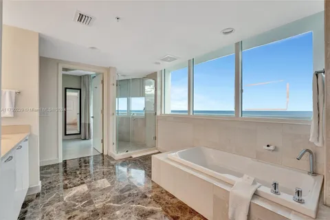 a bathroom with a tub a sink and a shower