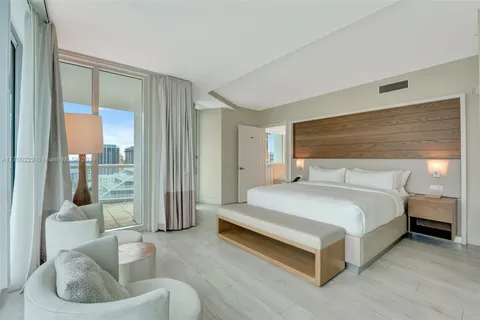 a spacious bedroom with a bed and glass window