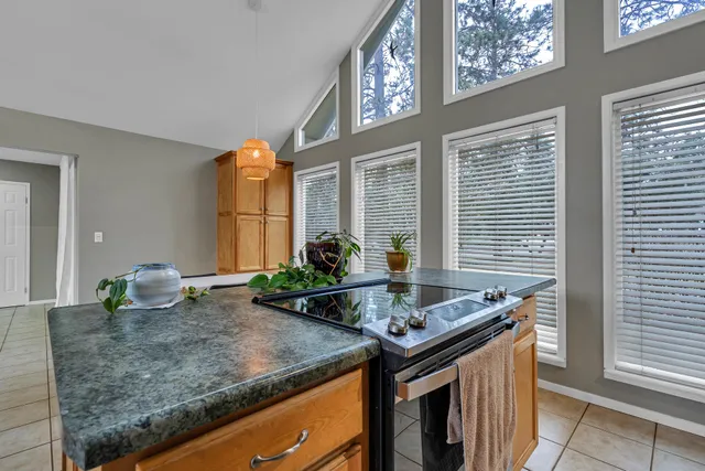 a kitchen with stainless steel appliances granite countertop a sink dishwasher a stove and a refrigerator