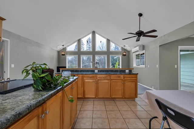 a kitchen with stainless steel appliances granite countertop a sink a stove and a wooden floors