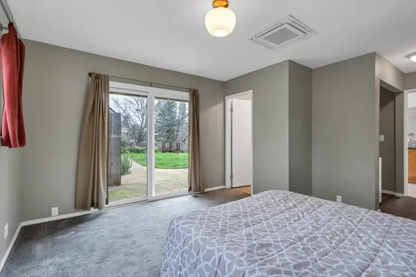 an empty room with a chandelier fan and windows