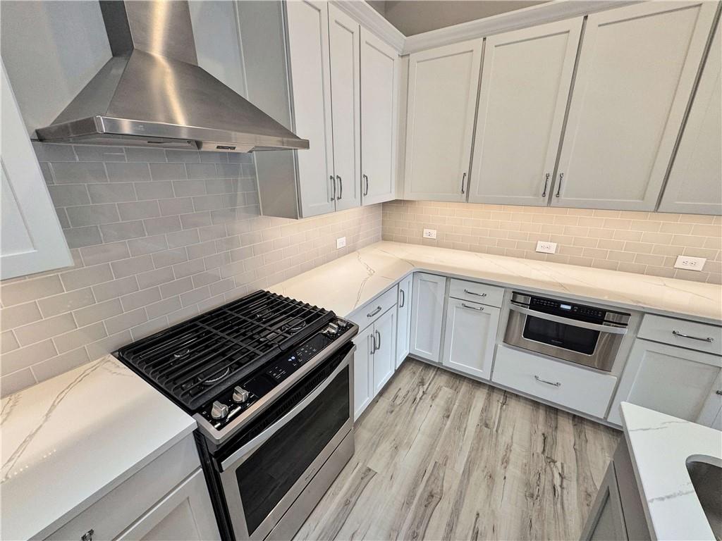 677 Stickley Oak Way Woodstock, GA 30189 - Photo 11 of 30 a kitchen with a stove and white cabinets