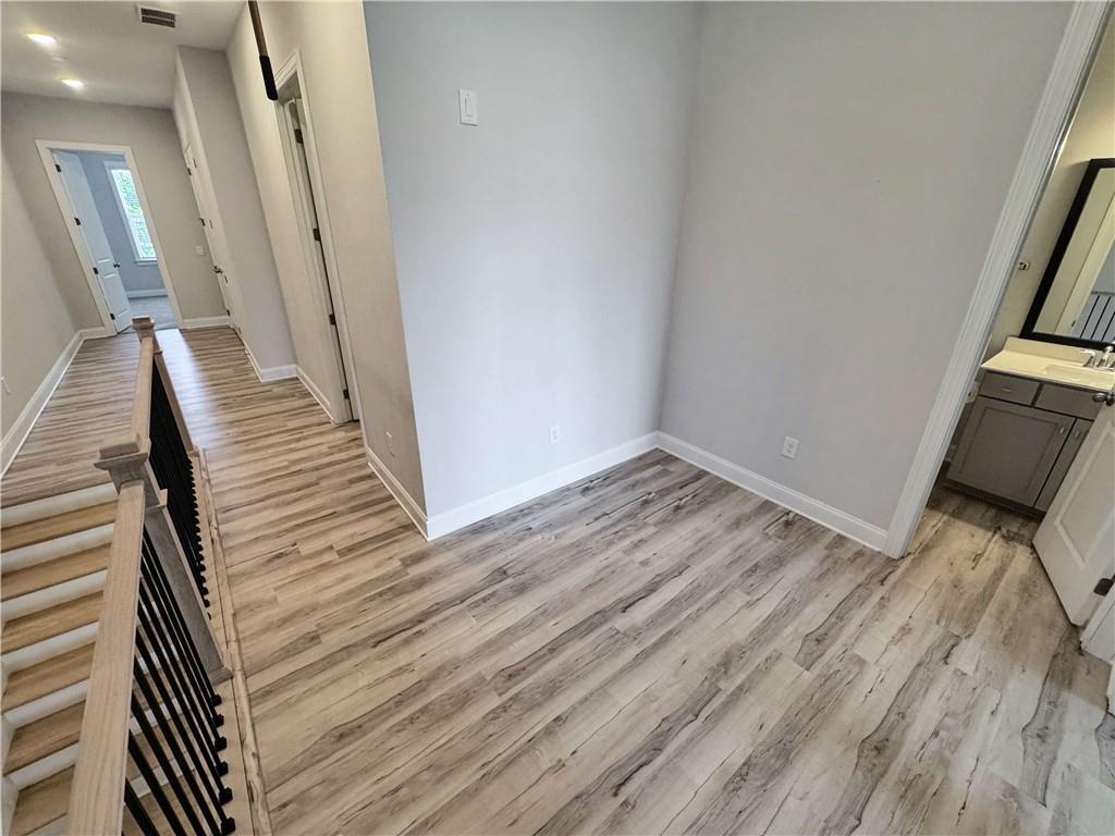 677 Stickley Oak Way Woodstock, GA 30189 - Photo 14 of 30 a view of a hallway with wooden floor and staircase