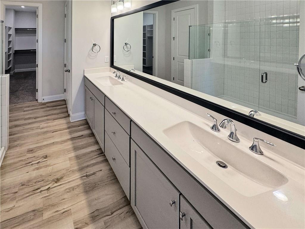677 Stickley Oak Way Woodstock, GA 30189 - Photo 18 of 30 a bathroom with a double vanity sink and mirror
