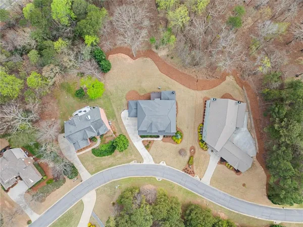 an aerial view of a house with a yard and large trees