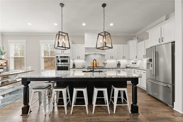 a kitchen with stainless steel appliances kitchen island granite countertop a sink a stove and a dining table