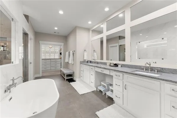 a bathroom with a double vanity sink mirror and bathtub