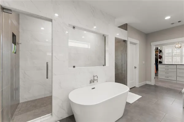 a bathroom with a white tub shower and sink