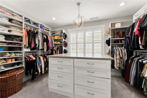 a view of walk in closet with clothes and shoes