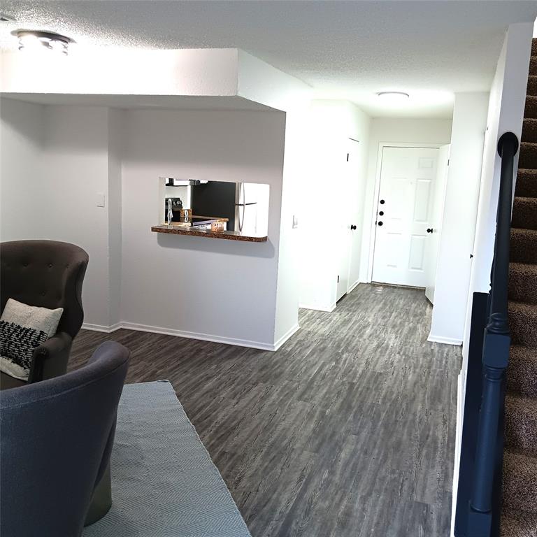 708 West Collins Street Denton, TX 76201 - Photo 13 of 40 Living area featuring stairway, light gray wood-pattern vinyl plank flooring, and a textured ceiling
