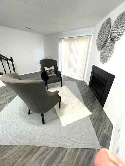 708 West Collins Street Denton, TX 76201 - Photo 15 of 40 Living room with light gray wood-pattern vinyl plank flooring, a textured ceiling, and a fireplace