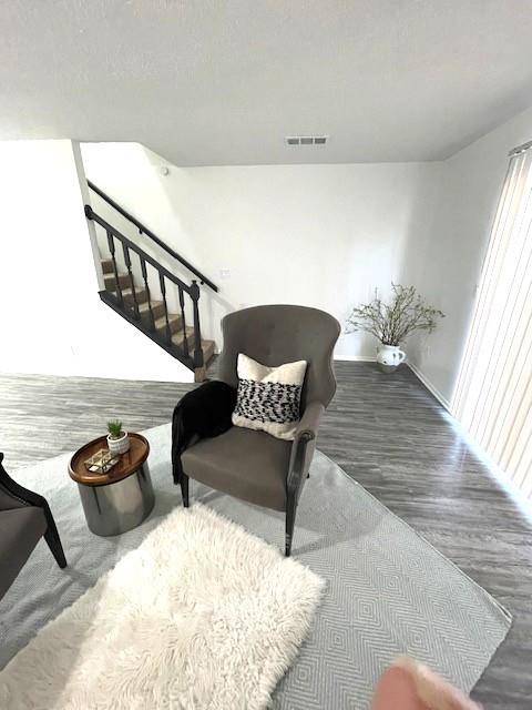 708 West Collins Street Denton, TX 76201 - Photo 17 of 40 Living area featuring light gray wood-pattern vinyl plank flooring, a textured ceiling, and stairway
