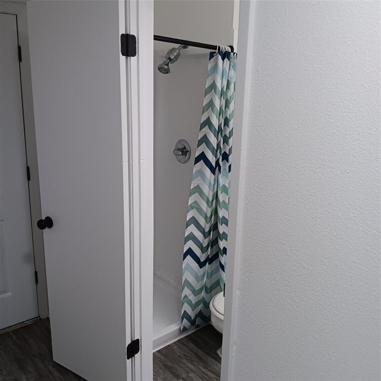 708 West Collins Street Denton, TX 76201 - Photo 4 of 40 Bathroom with a stall shower and light gray wood-pattern vinyl plank flooring