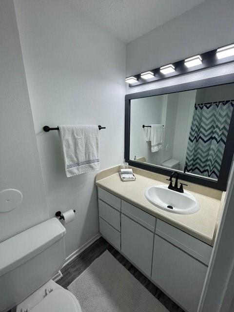 708 West Collins Street Denton, TX 76201 - Photo 5 of 40 Bathroom with a textured ceiling, vanity, light gray wood-pattern vinyl plank flooring, and a stall shower with shower curtain