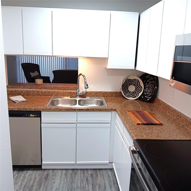 708 West Collins Street Denton, TX 76201 - Photo 9 of 40 Kitchen featuring stainless steel appliances, light gray wood-pattern vinyl plank flooring, white cabinets, and a textured ceiling