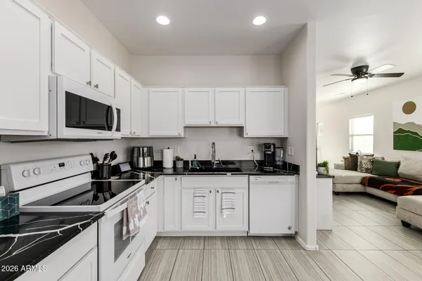 a kitchen with granite countertop a sink a stove and cabinets