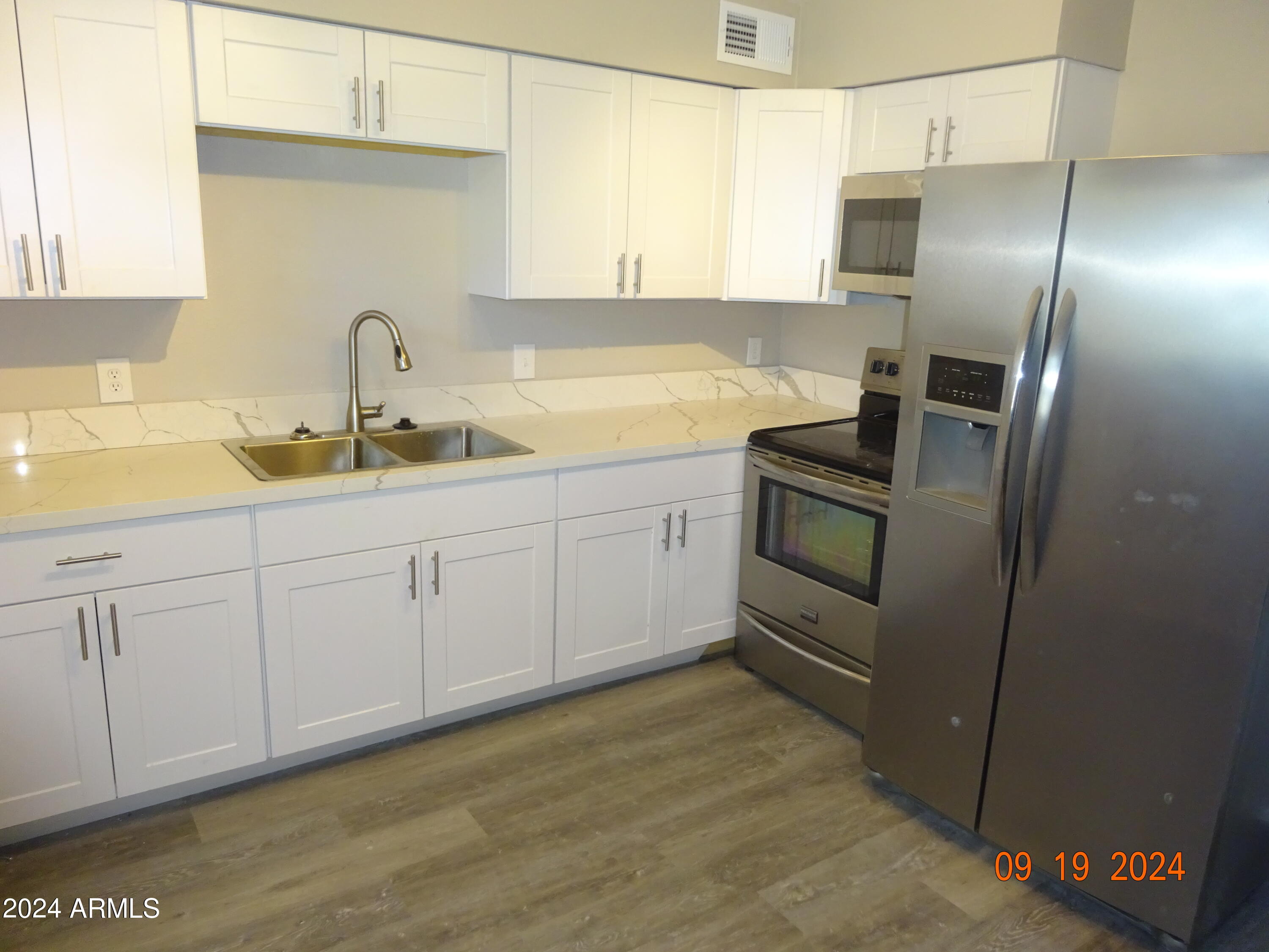 341 East Vogel Avenue, Unit 2 Phoenix, AZ 85020 - Photo 3 of 12 a kitchen with stainless steel appliances and white cabinets