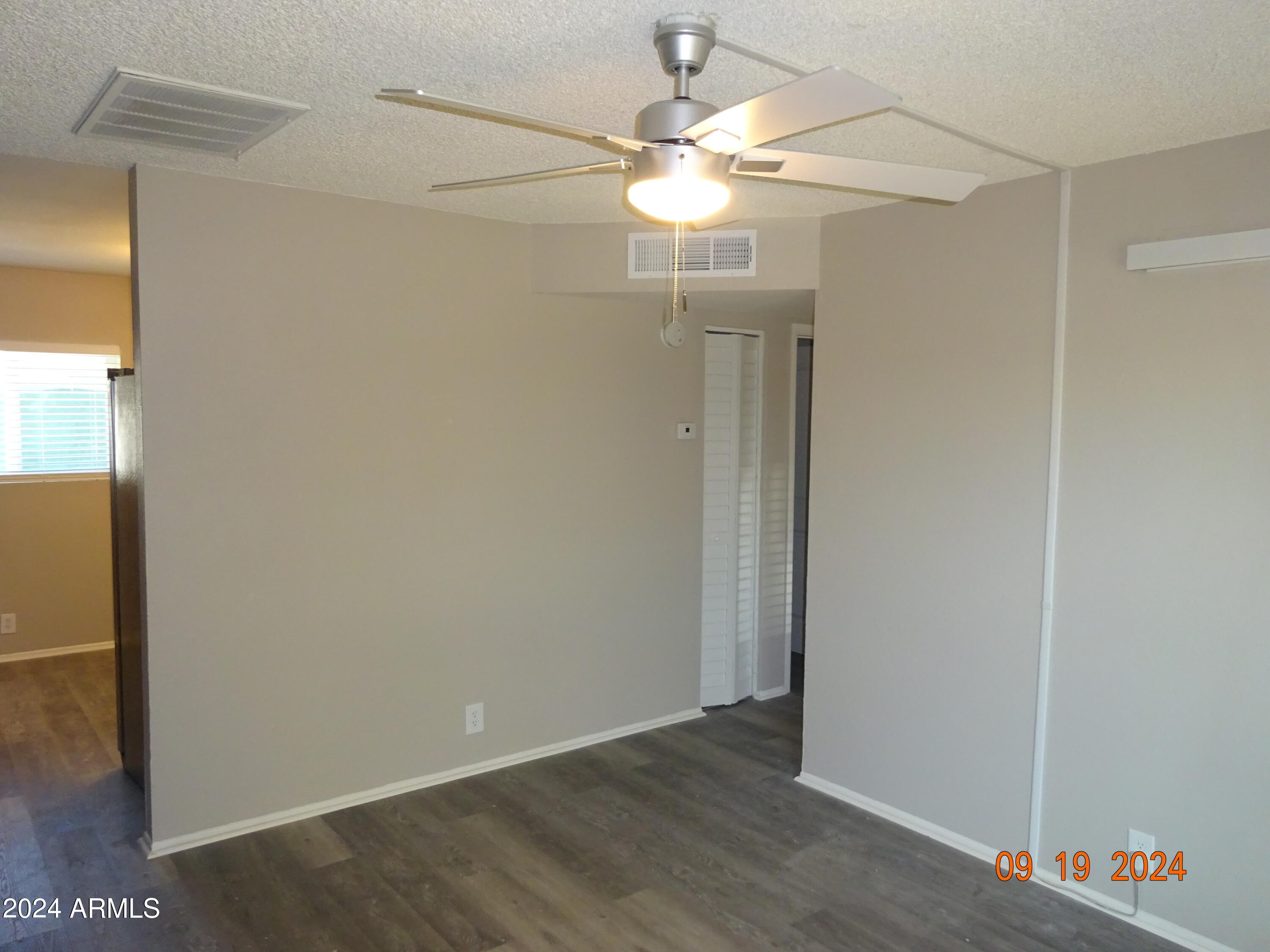 341 East Vogel Avenue, Unit 2 Phoenix, AZ 85020 - Photo 5 of 12 an empty room with wooden floor fan and window
