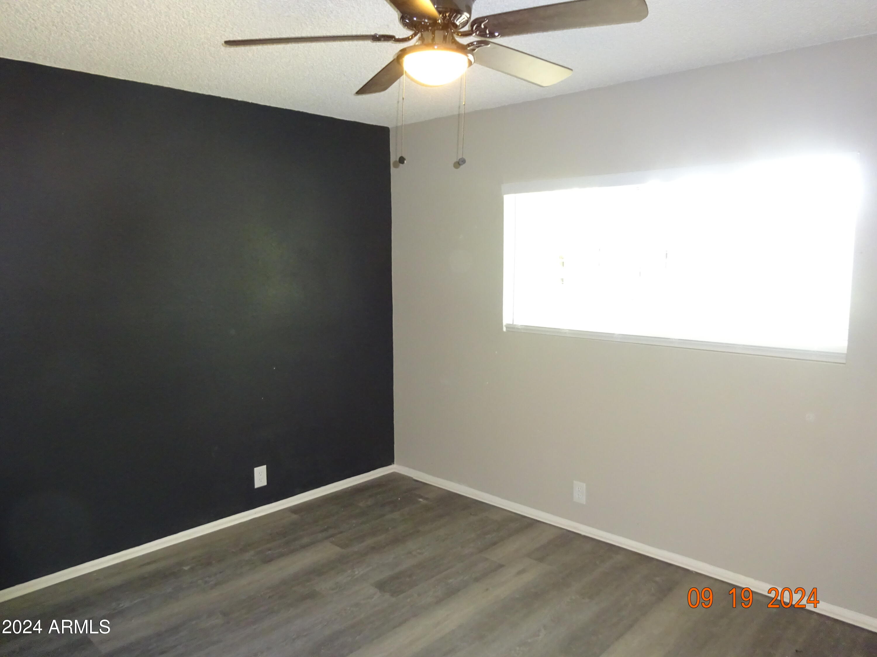 341 East Vogel Avenue, Unit 2 Phoenix, AZ 85020 - Photo 10 of 12 an empty room with a window and a ceiling fan