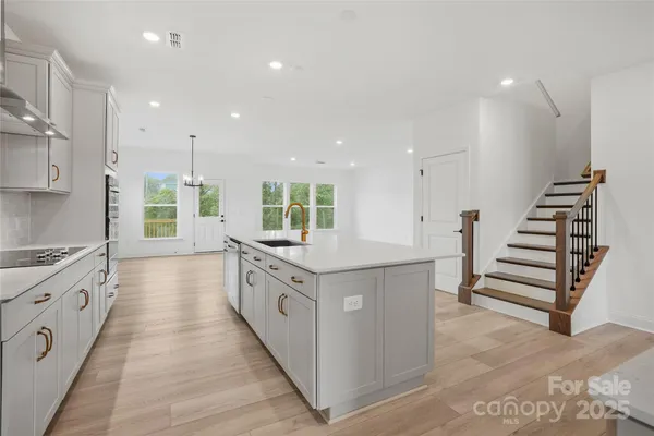 an empty room with wooden floor cabinet and windows