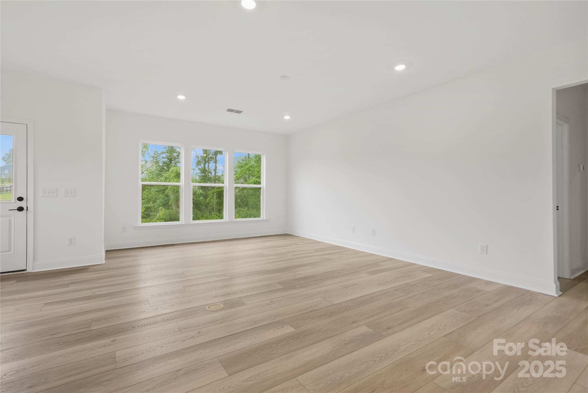 9373 Moss Plantation Avenue Northwest Concord, NC 28027 - Photo 13 of 27 a view of an empty room with wooden floor and a window