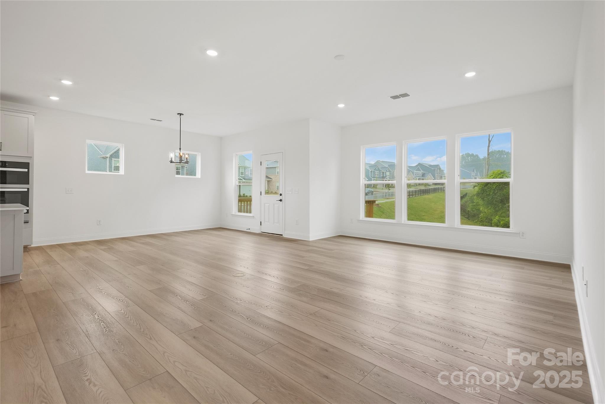 9373 Moss Plantation Avenue Northwest Concord, NC 28027 - Photo 15 of 27 an empty room with wooden floor and windows