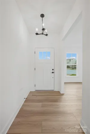 an empty room with wooden floor ceiling fan and windows
