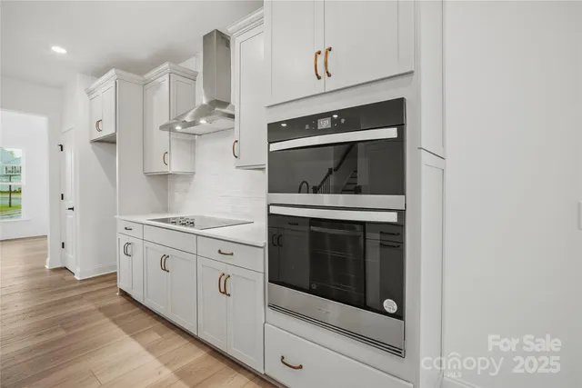 a kitchen with white cabinets appliances and sink
