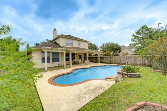 a view of a house with swimming pool and sitting area