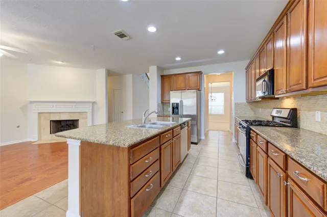 a large kitchen with stainless steel appliances granite countertop a stove and a sink