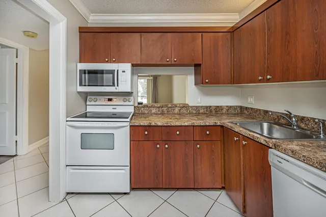 a kitchen with granite countertop a sink stainless steel appliances and cabinets