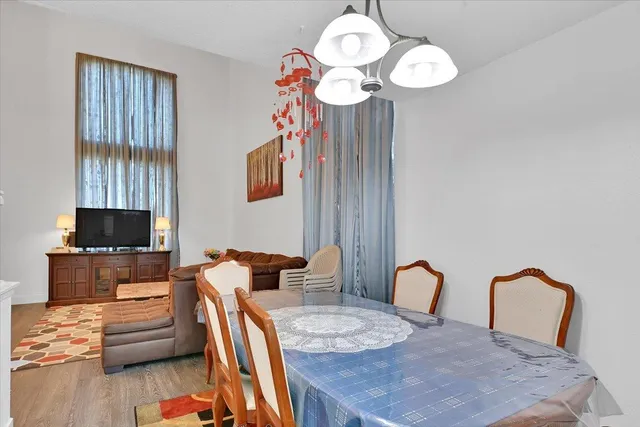 a view of a dining room with furniture a chandelier and wooden floor