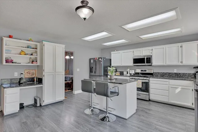 a kitchen with white cabinets and stainless steel appliances