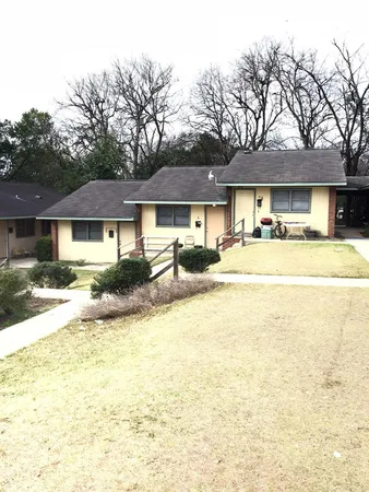 a front view of a residential houses with yard and trees
